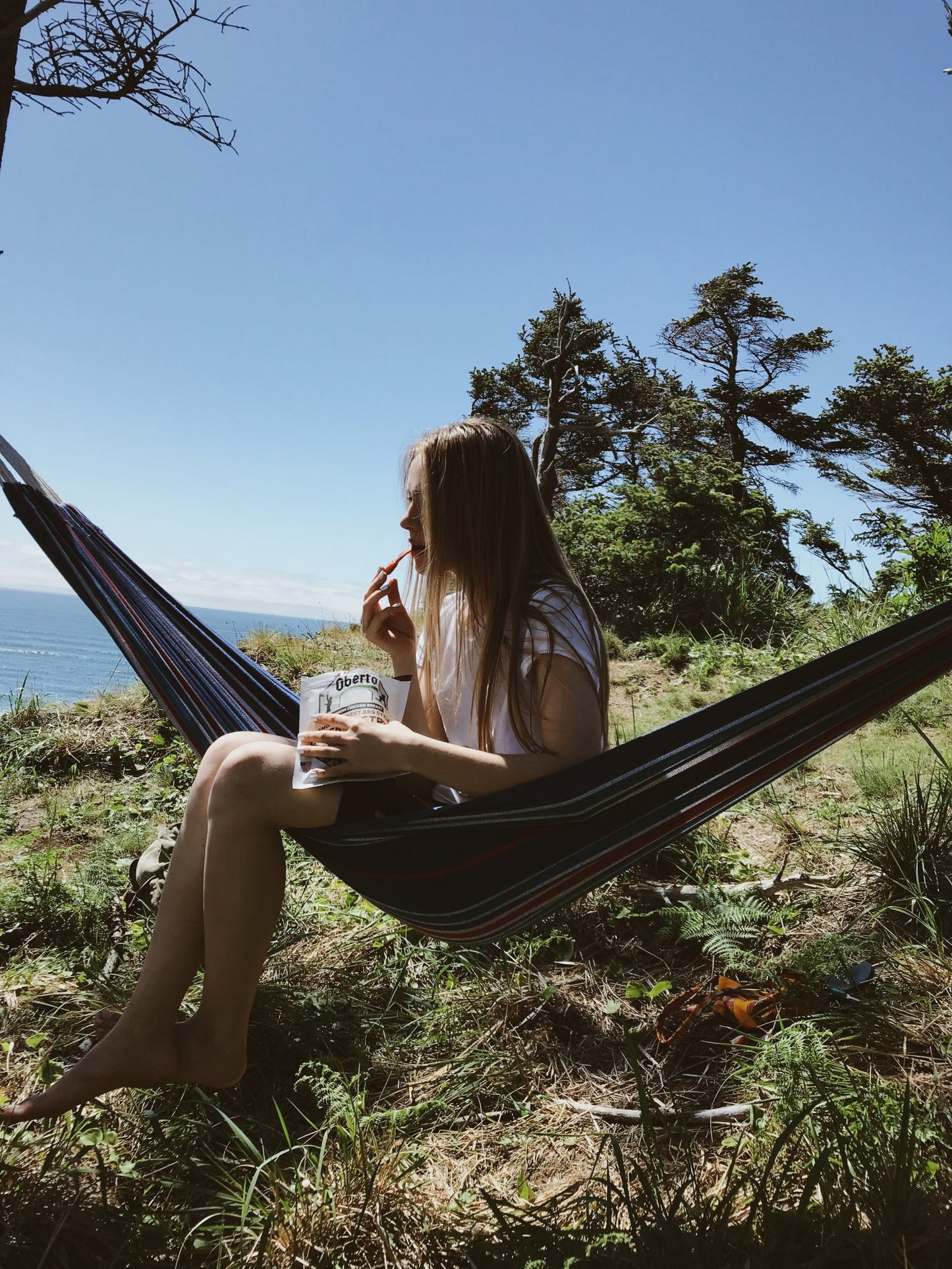 Girl enjoys Oberto Jerky in a hammock