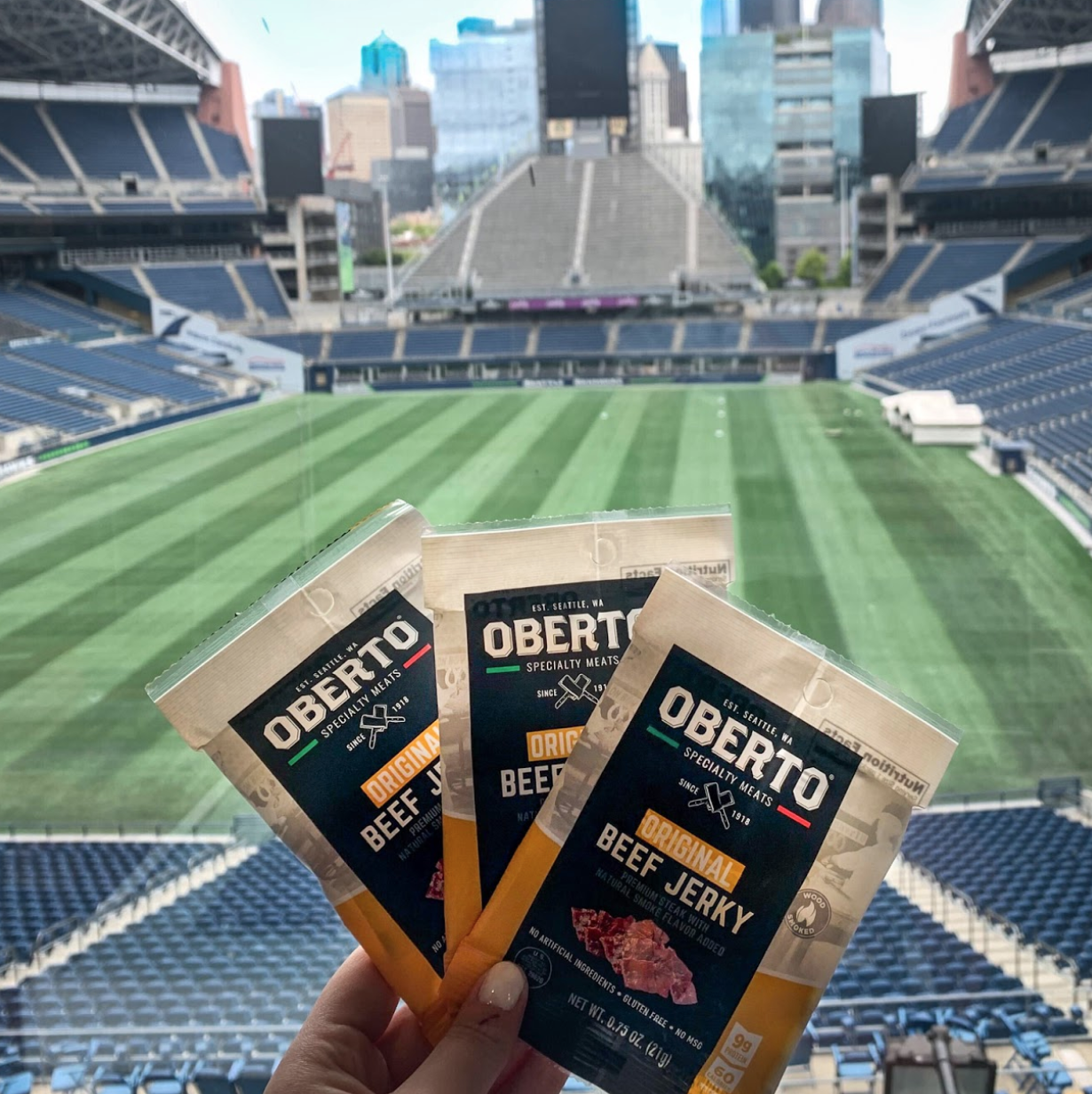 3 bags of  Oberto Jerky being held our with Century Link Field in the background 