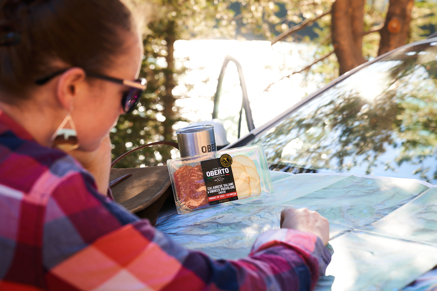 Female reads a map and enjoys Oberto Charcuterie, searching for her next adventure 